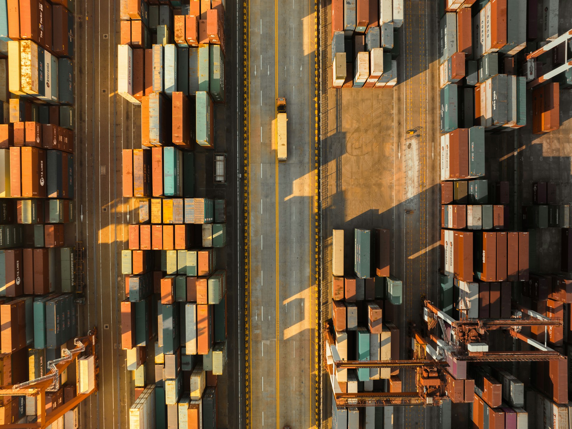 Vista aérea de contenedores apilados en un puerto industrial — metáfora visual de orquestación de contenedores a escala